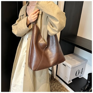 Close-up of vintage brown PU leather shoulder bag with glossy finish and neat stitching