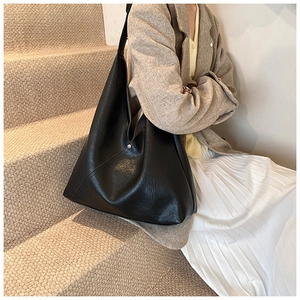 Detail view of the soft PU leather texture and spacious design on this black tote bag