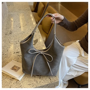 Détail du cabas gris givré avec nœud beige et poignées en cuir haut de gamme