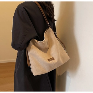 Detail of beige PU leather hobo bag with brown strap and Fashion logo plate