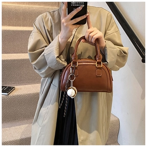 Detailansicht einer braunen PU-Lederhandtasche mit eleganten goldenen Beschlägen