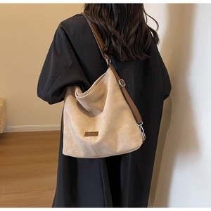 Close-up of beige PU leather shoulder bag featuring adjustable brown strap and metal buckle