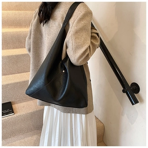 Modern black PU leather hobo bag with pebble texture styled in a professional setting