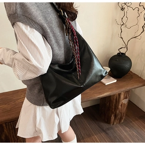 Detailed side view of the large black PU leather hobo bag with striped scarf accent