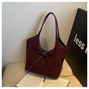 Détail du grand nœud décoratif sur le sac cabas en daim mat bordeaux élégant
