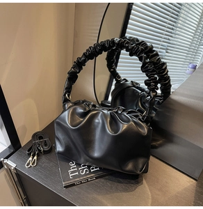 Detail of black pleated cloud bag with scrunchie handle and adjustable long strap