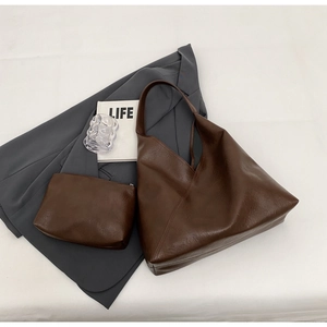 Flat lay of a large dark brown tote bag set with a matching small zipper pouch on a white background