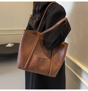 Detailed macro of brown PU leather tote bag showing vintage texture and side pocket