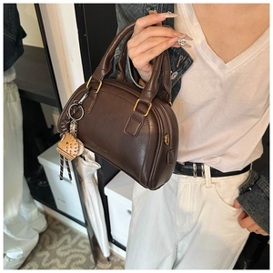 Detail der dunkelbraunen Boston-Tasche aus PU-Leder mit Baseball-Handschuh-Anhänger
