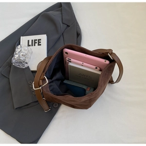 Macro view of dark brown suede bucket bag interior showing spacious storage capacity