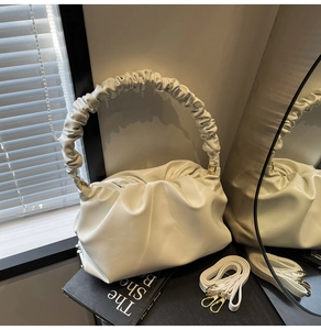 Detail showing the white pleated cloud bag texture and detachable shoulder strap design