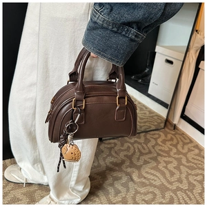 Detailansicht braune Boston-Tasche aus PU-Leder mit dekorativem Baseballhandschuh-Anhänger