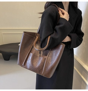 Detail of deep brown PU leather tote bag showing vintage texture and double handle design