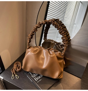 Detail of brown pleated cloud bag made of PU leather with detachable adjustable shoulder strap