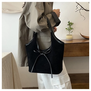 Détail du sac cabas en daim noir avec nœud en cuir et finition texturée