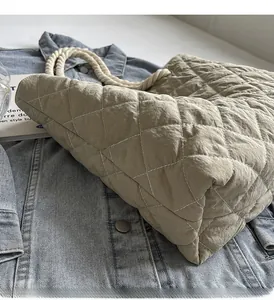 Close-up of khaki quilted tote bag featuring diamond pattern and white rope handles