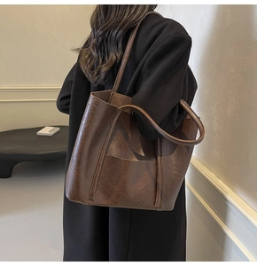 Detail of a large vintage brown PU leather tote bag with long double shoulder straps