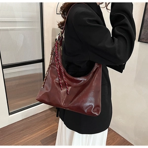 Fashionable dark red PU leather shoulder bag featuring a glossy finish and woven strap detail