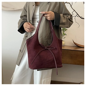 Gros plan du sac fourre-tout bordeaux mat avec un nœud décoratif en ruban long
