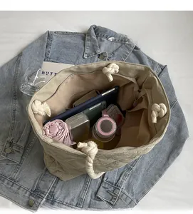 Detailed view of the beige quilted tote bag interior showing large capacity for items