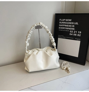 Macro shot of white pleated cloud bag details with premium faux leather texture
