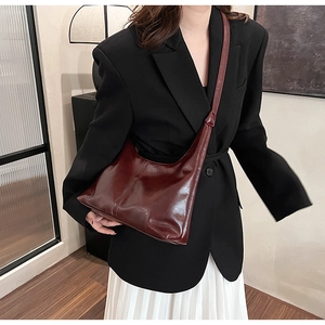 Deep burgundy glossy PU leather hobo bag styled with a black blazer and white skirt