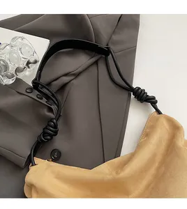Détail du sac à bandoulière en daim kaki avec nœud et bandoulière en corde noire