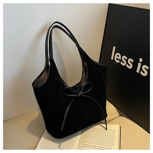 Gros plan du sac cabas en daim noir montrant les finitions cuir et le nœud