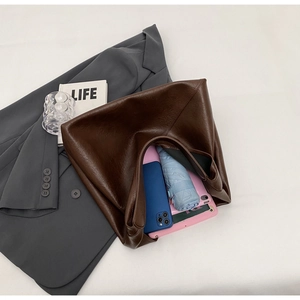 Dark brown faux leather tote bag showing spacious interior with tablet and umbrella