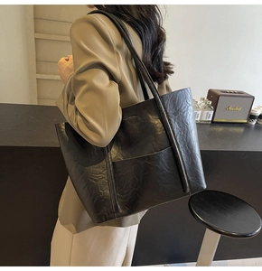 Detail of premium black PU leather texture and durable handles on a large tote bag