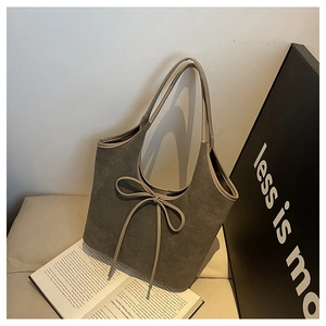 Vue détaillée du sac cabas en daim gris avec nœud minimaliste et texture souple