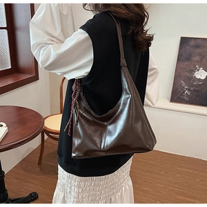 Detail of deep brown PU leather shoulder bag with a stylish red checkered scarf accent
