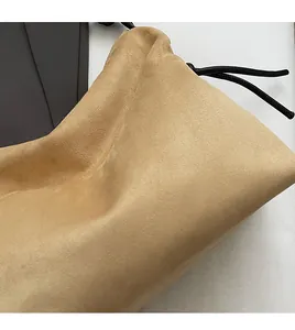 Détail en daim kaki doux avec cordon noir et texture mate lisse sur le sac bandoulière