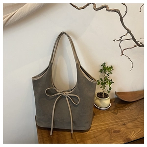Gros plan détaillé du sac cabas en daim givré gris foncé avec un nœud décoratif élégant