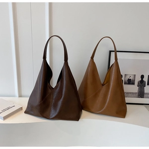 Detailed close-up of dark brown and caramel PU leather tote bags on a white display stand