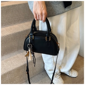 Klassische schwarze PU-Boston-Tasche mit goldenen Beschlägen und elegantem Quastenanhänger