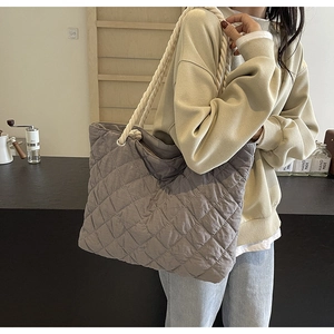 Detailed shot of grey quilted fabric tote bag with white thick rope shoulder straps