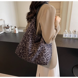 Detail of trendy leopard print tote bag in plush fabric with slim leather straps