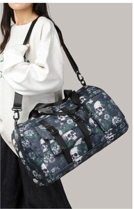 Détail du sac de voyage avec motif tête de mort et fleurs, doté de poches extérieures