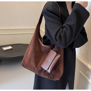Detail of dark brown matte suede hobo bag with a side leather pouch and logo engraving