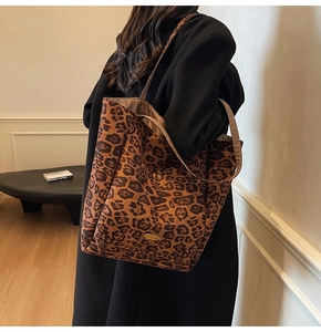 Detail showing leopard print texture and golden oval metal handmade tag on tote bag