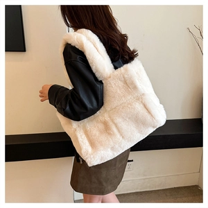 Modèle portant un grand sac fourre-tout matelassé en peluche crème avec larges bandoulières