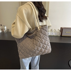 Detail view of the quilted texture and thick cotton rope handle on this grey tote bag