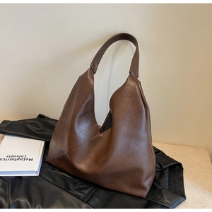 Detail of vintage brown pebble leather shoulder bag with unique diagonal V-shaped opening