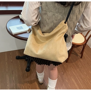 Détail du sac hobo en daim jaune gingembre avec cordon noir et fine bandoulière