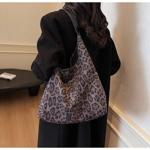 Rear view of a model wearing the leopard print suede tote bag with black leather strap