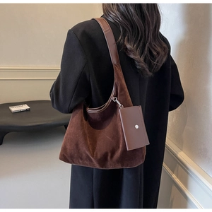 Detail of dark brown faux suede tote bag with matching card holder pouch on black wool coat