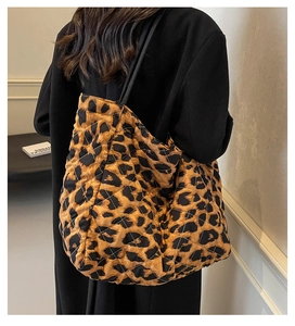Detail showing the large leopard print quilted tote bag worn on a woman's shoulder