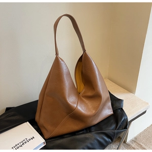 Detailed view of brown leather tote bag with soft texture and bright yellow lining