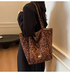 Close-up of leopard print velvet tote bag with a golden handmade metal label